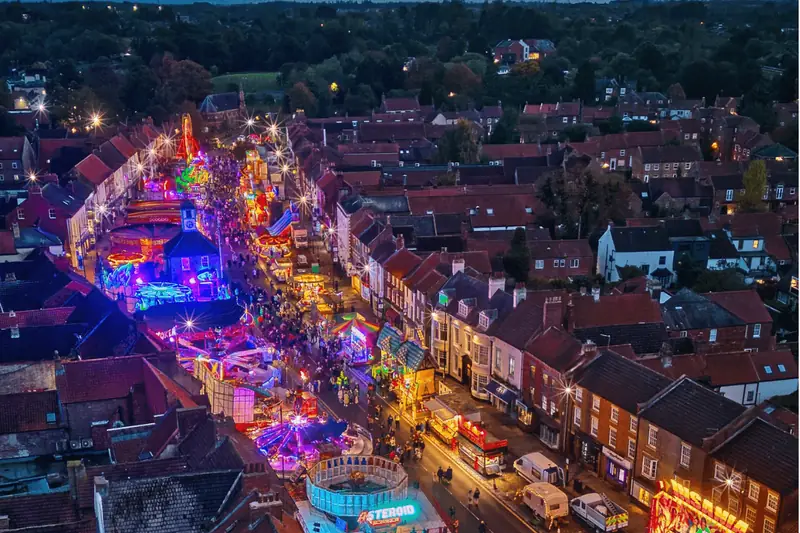 Funfair lights along a town high street at night