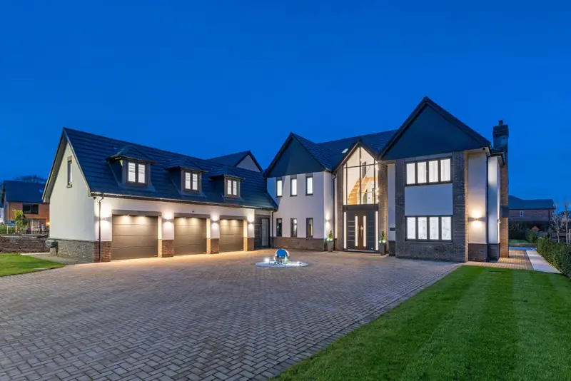 Detached home with an illuminated driveway at dusk